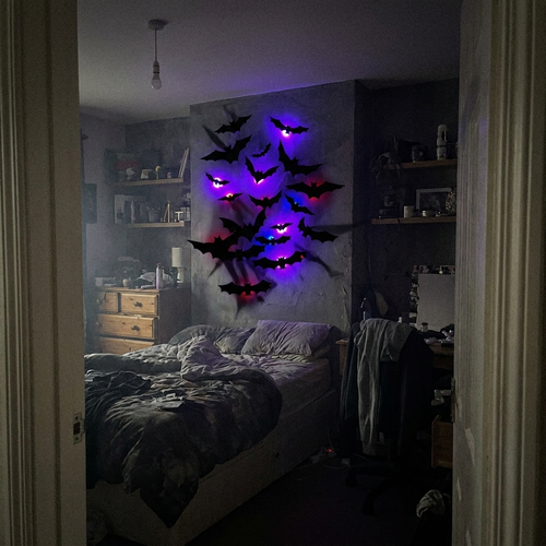 Glow Bats glowing purple in a dark bedroom doorway view
