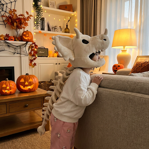 Person wearing the white triceratops plush head hood